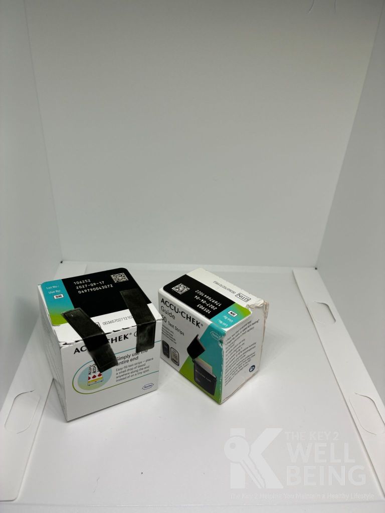 Two Accu-Chek Guide test strip boxes with black tape and loose shrink wrap — examples of damaged diabetic supply packaging not accepted for full buyback payout